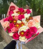 Un bouquet de fleurs colorées avec des pétales dans une variété de teintes vibrantes.